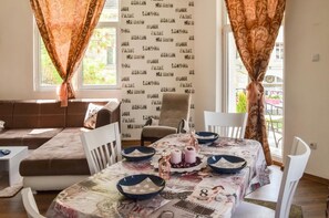 A dining area with a table set for four, a sofa, and a chair.