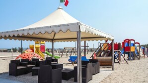 A beachside playground with a canopy, play structures, and seating areas. - Lovely apartment in villa for 5 guests with A/C, pool, WIFI, TV and terrace (Rosolina)