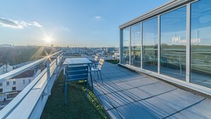 A rooftop terrace with a clear view of the city skyline, a seating area with chairs, and a glass wall reflecting the surroundings. - Break & Home Paris Italie Porte De Choisy (Ivry-sur-Seine)