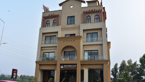 A multi-story building with a sign for "Second Cup Coffee Company" on the ground floor. - River View Residency (Rawalpindi)