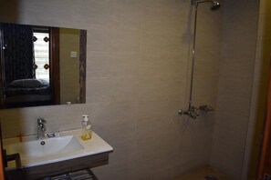 A bathroom with a sink, mirror, and shower. - River View Residency (Rawalpindi)
