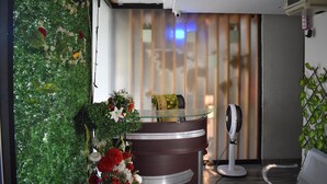 A reception area with a glass counter, a fan, and a decorative wall. - River View Residency (Rawalpindi)