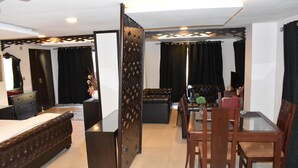 Una camera d'albergo con un letto, un tavolo da pranzo con sedie, un divano, una TV e un pannello decorativo.