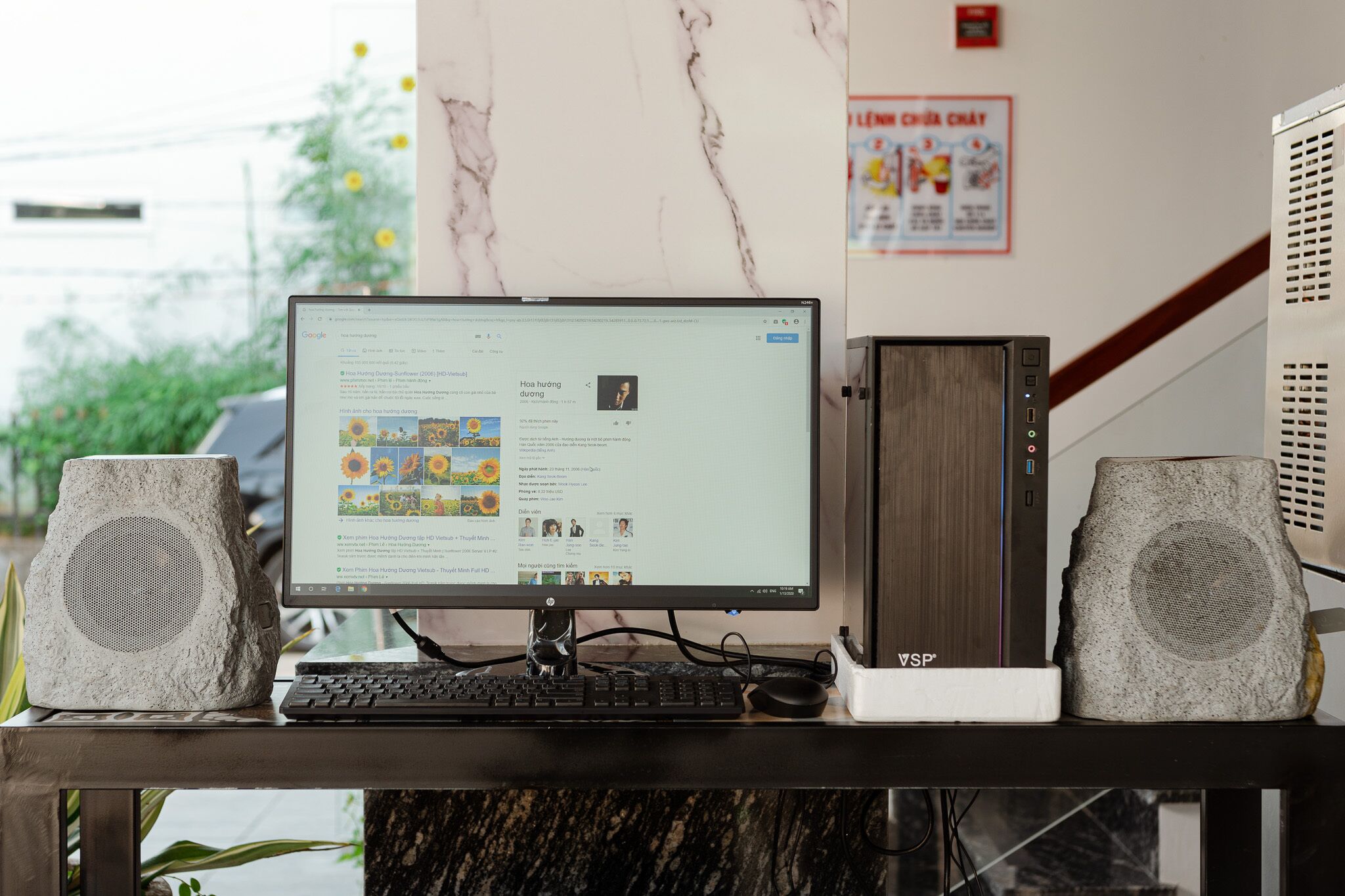 A desktop computer with a monitor, keyboard, and two speakers on a desk.