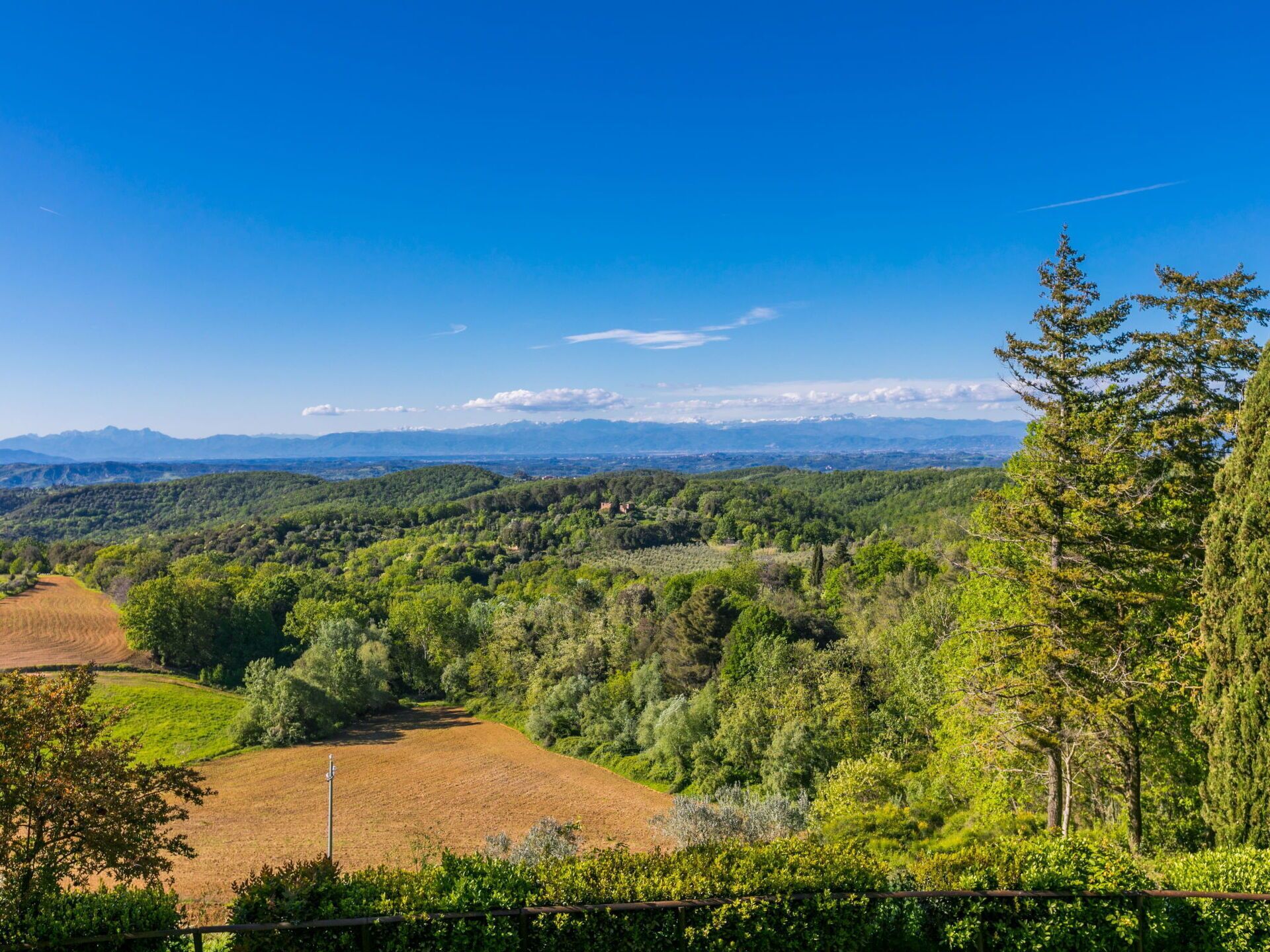 A panoramic view of a mountainous landscape with dense forests and fields.