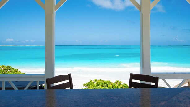 Ein überdachter Sitzbereich mit Blick auf Strand und Meer.