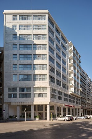 A multi-story hotel with a modern facade, large windows, and a parking lot with several cars. - Boss Boutique Athens (Athens)