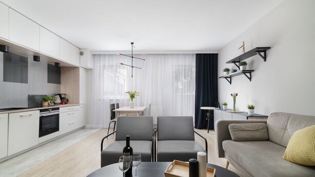 Un salon moderne comprenant un canapé, une table à manger et un coin cuisine.