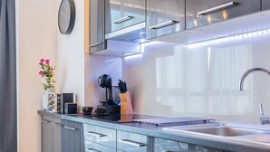 A modern kitchen with sleek cabinetry, a stainless steel sink, and a built-in oven. - Easy Rent Apartments - SKY (Lublin)