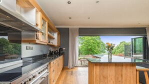 A modern kitchen with a large island, built-in appliances, and a view of the outdoors. - Poundgate Park Holiday House 8 Bedroom in 2 adjoining properties ,1h from London (Crowborough)