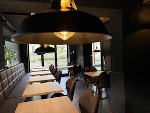 A restaurant interior with booths, tables, and hanging pendant lights. - Moseltel Ernst/cochem (Ernst)