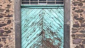A weathered turquoise door with a chevron pattern, set in a stone wall with a simple arch above. - Moseltel Ernst/cochem (Ernst)