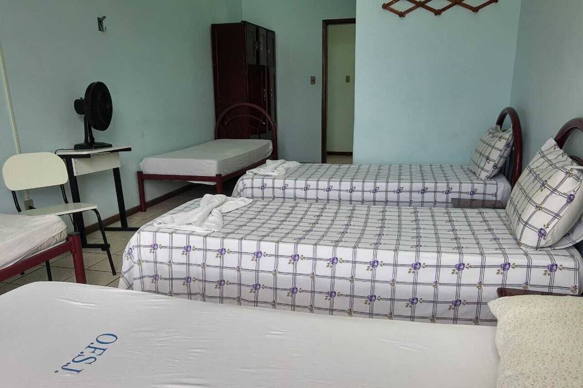 Una habitación con dos camas, un escritorio, una silla y un armario.