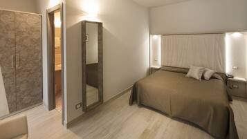 A modern bedroom with a large bed, a walk-in closet, and a mirror.