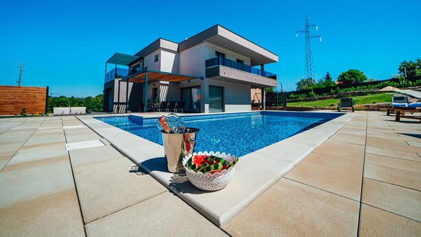A modern two-story house with a swimming pool, outdoor seating, and a view of a power line tower. - Luxury villa Tori in Imotski, pool (Lokvicici)