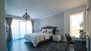 A bedroom with a large bed, a nightstand, a chair, a desk, and a window with curtains. - Luxury villa Tori in Imotski, pool (Lokvicici)