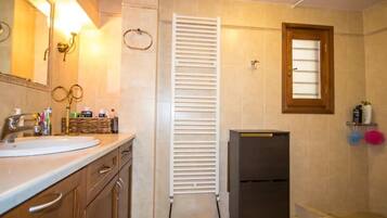 Ein Badezimmer mit Waschbecken, Spiegel, Handtuchhalter, Heizung und Toilette.