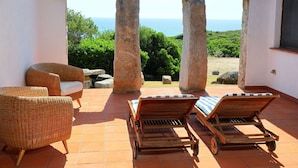 A terrace with wicker furniture and a view of the sea. - Cosy apartment in villa for 6 people with A/C, TV, terrace and pets allowed (Castiadas)