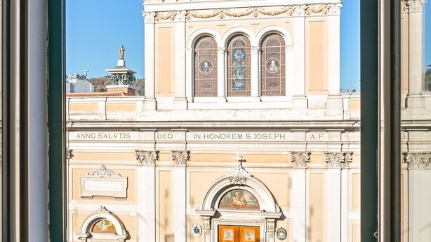 A building with classical architecture, featuring a central dome, arched windows, and a prominent entrance.