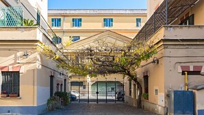 A narrow alleyway with a gated entrance, leading to a building with a traditional architectural style.