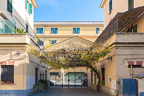 A narrow alleyway with a gated entrance, leading to a building with a traditional architectural style.