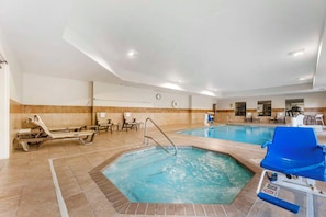 Una piscina de hotel con sillas de descanso y un jacuzzi.