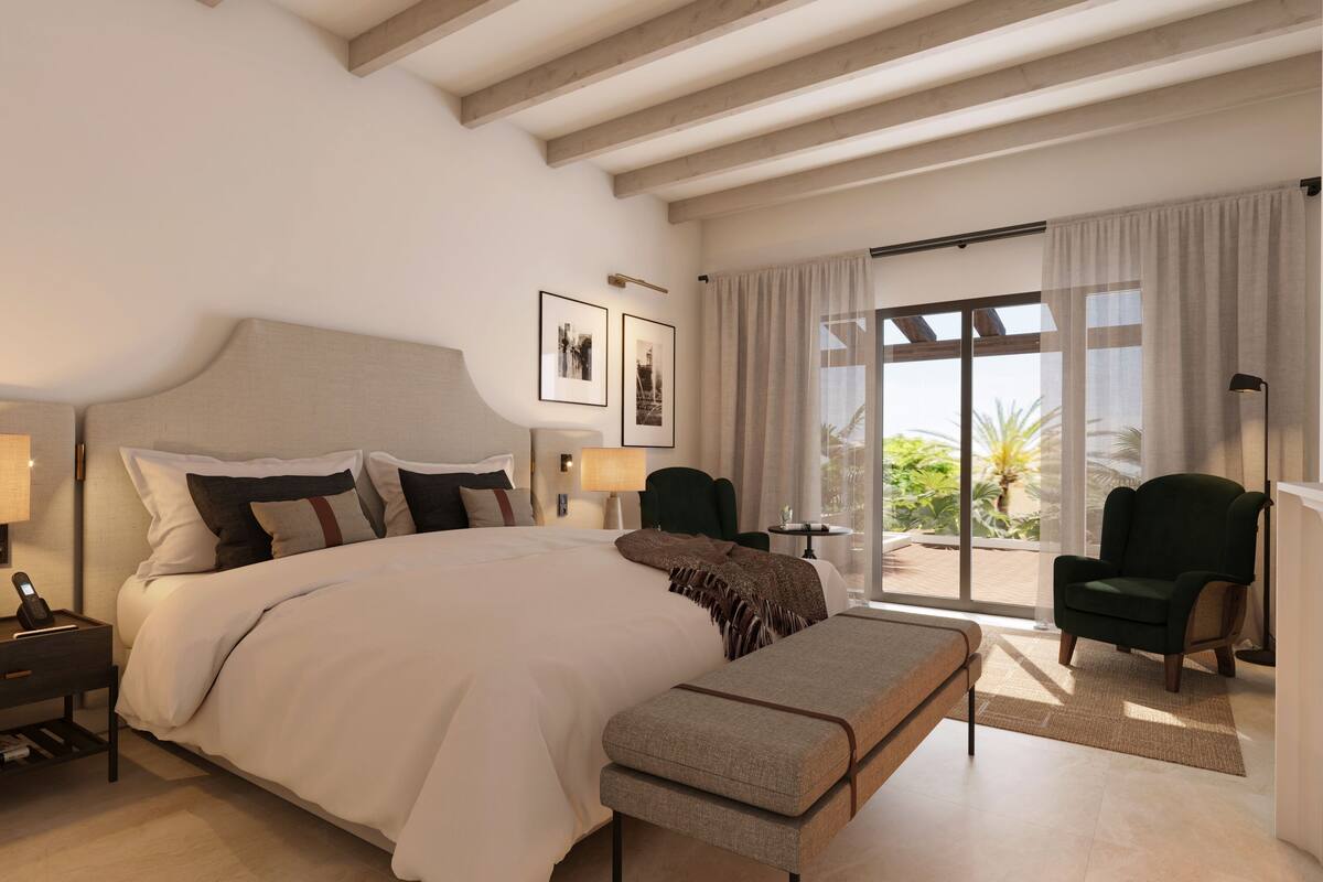 Habitación de hotel moderna con una cama grande, una banca, un escritorio y una silla. Tiene un balcón con vistas al exterior.