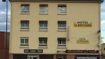 A multi-story building with signs for 'HOTEL DE BRETAGNE' and 'BRASSERIE DE LA GARE'.
