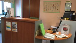 Un comptoir d’accueil d’hôtel avec un tableau d’affichage, un menu et une enseigne indiquant le nom de l’hôtel.