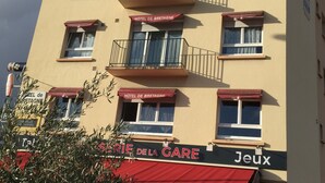 Un immeuble d’hôtel à plusieurs étages, doté de balcons, d’une marquise rouge et d’une enseigne indiquant « Hôtel de Bretagne ».