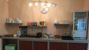 Une petite cuisine équipée d’une machine à café, d’un grille-pain, de bols et d’un réfrigérateur.