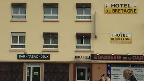 Un hôtel appelé «HÔTEL DE BRETAGNE», avec une enseigne indiquant que la réception se trouve au premier étage.