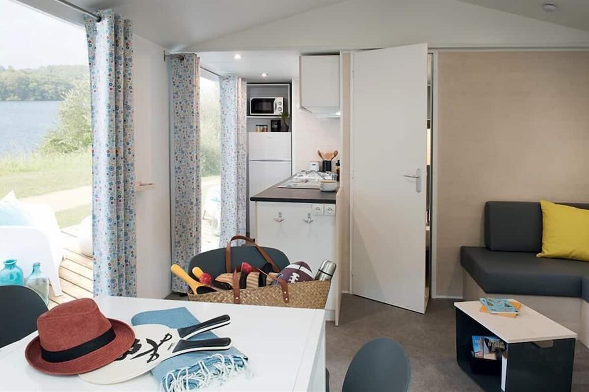 A compact room with a kitchenette, a dining area, and a sofa.