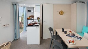 A modern kitchen with a microwave, a dining area with a table and chairs, and a view of the outdoors.