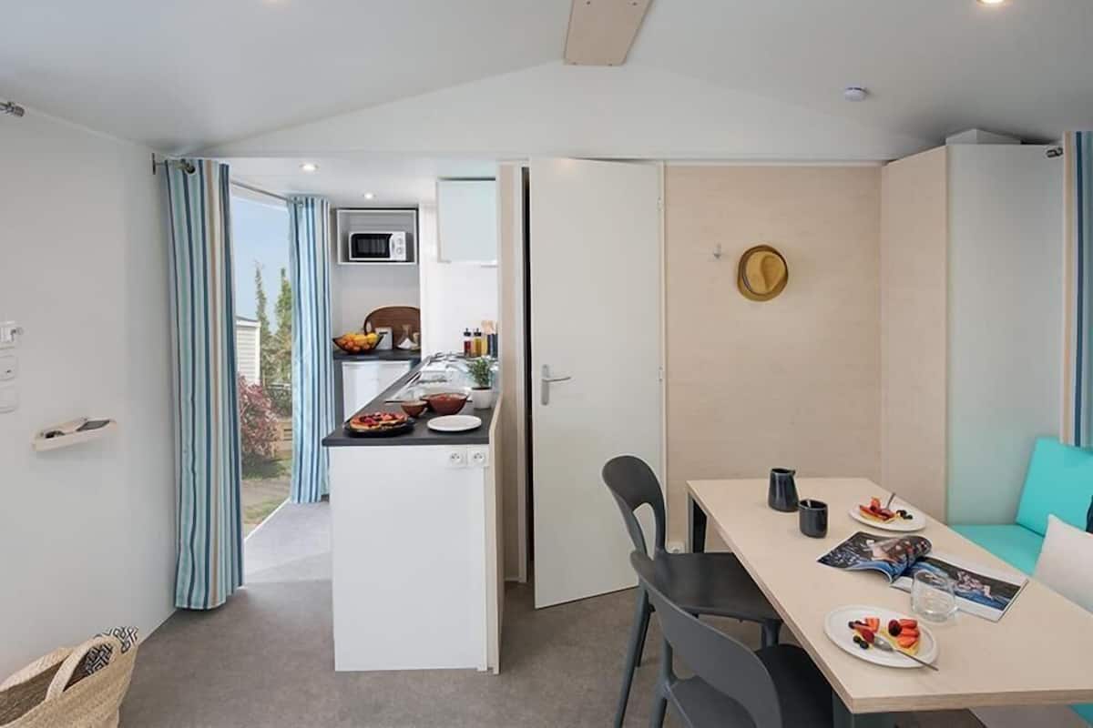 A modern kitchen with a microwave, a dining area with a table and chairs, and a view of the outdoors.