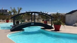 A swimming pool with a curved design and a bridge structure.