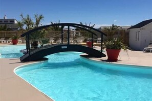 Een seizoensgebonden buitenzwembad en ligstoelen