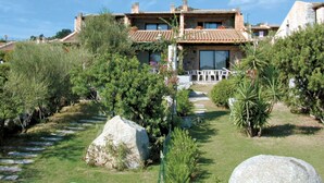 A two-story house with a garden pathway leading to a patio area. - Lovely apartment in villa for 6 people with A/C, TV, terrace and pets allowed (Sant'elmo)