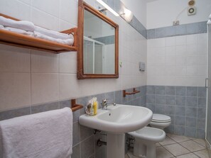 A bathroom with a white sink, a mirror, a toilet, and a towel rack. - Beautiful apartment in villa for 6 guests with A/C, TV, terrace and pets allowed (Sant'elmo)
