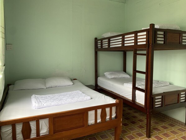 Een kamer met twee stapelbedden, elk voorzien van een matras en kussens.