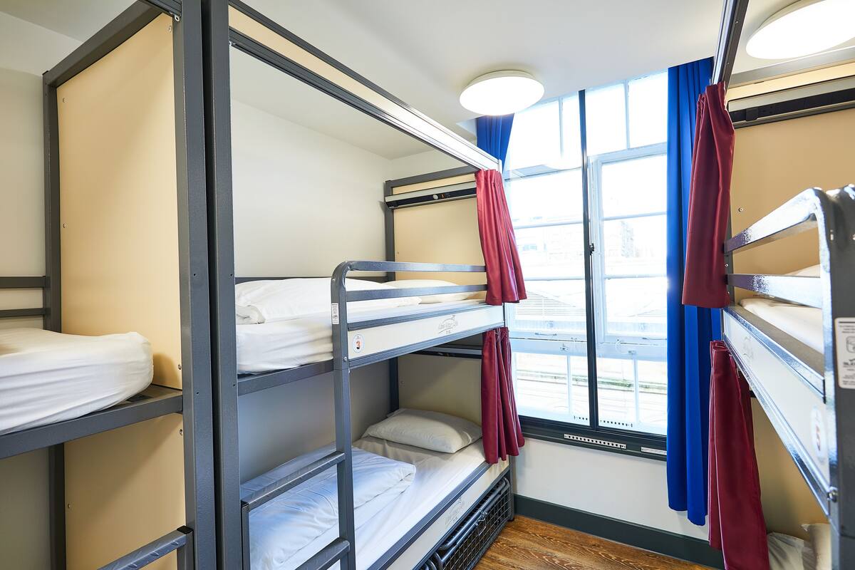Habitación con literas, ventana y cortinas.