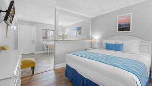 Hotellihuone, jossa on sänky, työpöytä ja tuoli.