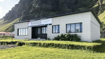 Een modern gebouw met de naam 'South Iceland Guesthouse' en een naambord.
