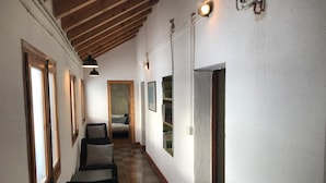 A hallway with wooden beams, a staircase, and a bed in the background. - Refugi Cap del Rec - Hostel (Lles)