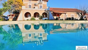 A large building with multiple arches and a swimming pool in front. - Casale del Vento (Aprilia)