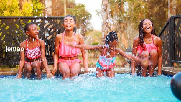 A group of people in a swimming pool with water splashing around them. - La Fiato Luxury Lodge (Polokwane)