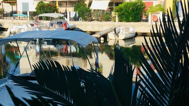 A marina with boats docked, a building with balconies, and a clear sky. - Marina Petite Belge à Aigues Mortes (incl city bikes on request) (Aigues-Mortes)