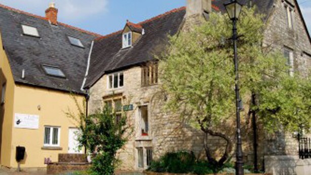 A traditional stone building with a red-tiled roof, a brick pathway, and a small tree in the foreground. - Cotswolds Valleys Accommodation-Med Hall (Stroud)