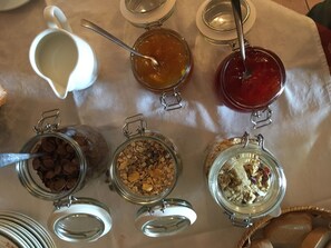A table with various food items in jars and a jug. - Hotel Il Fondaccio (Lizzano in Belvedere)