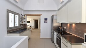 Una cocina moderna con armarios blancos, electrodomésticos de acero inoxidable y una isla central.